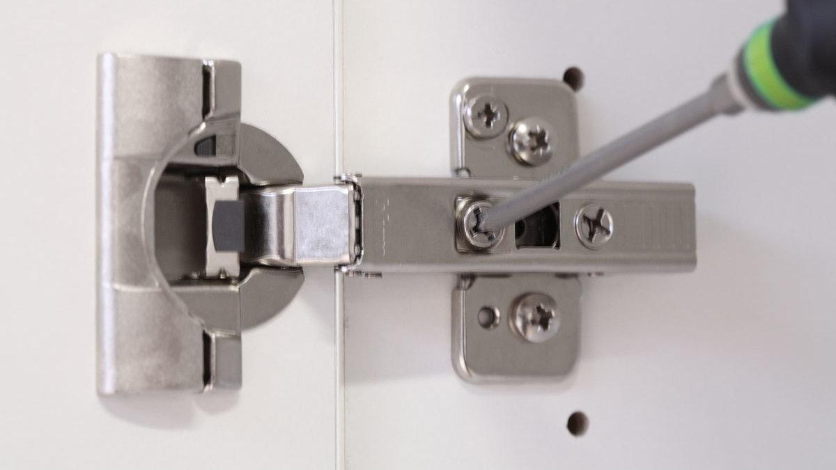 Detailaufnahme eines mit Schraubendreher nachjustierbaren Türscharniers