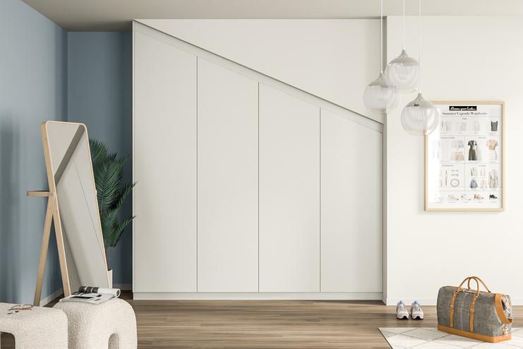 Maßgeschneiderter, weißer Kleiderschrank, der sich nahtlos in die Schräge des Raumes einfügt, mit klaren Linien und puristischem Design.